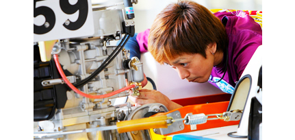 Japanese boat racer inspecting motor before the race