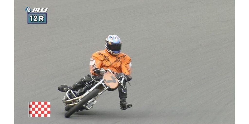 Daisuke Nagai crossing the finish line to win the 12R race in his orange suit at Kawaguchi Auto Race (Image: Kawaguchi Auto Race)